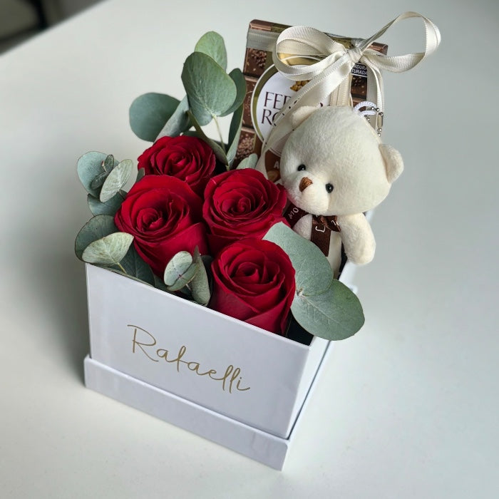 Arreglo floral en caja con osito, bombones Ferrero y mensaje personalizado entrega en Madrid