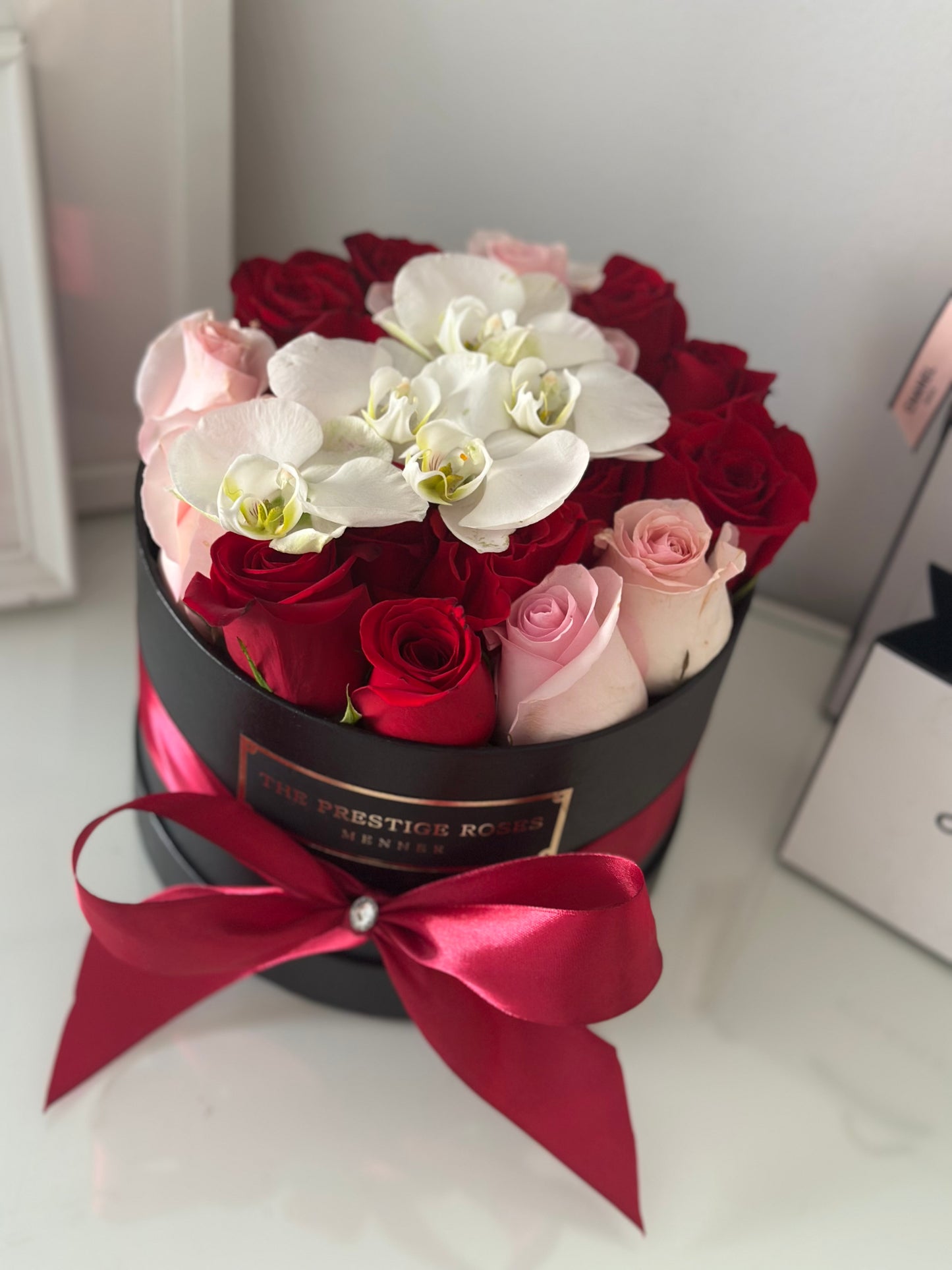 Caja mediana elegante con rosas rojas, rosas rosadas y orquídeas blancas frescas, a domicilio en Madrid