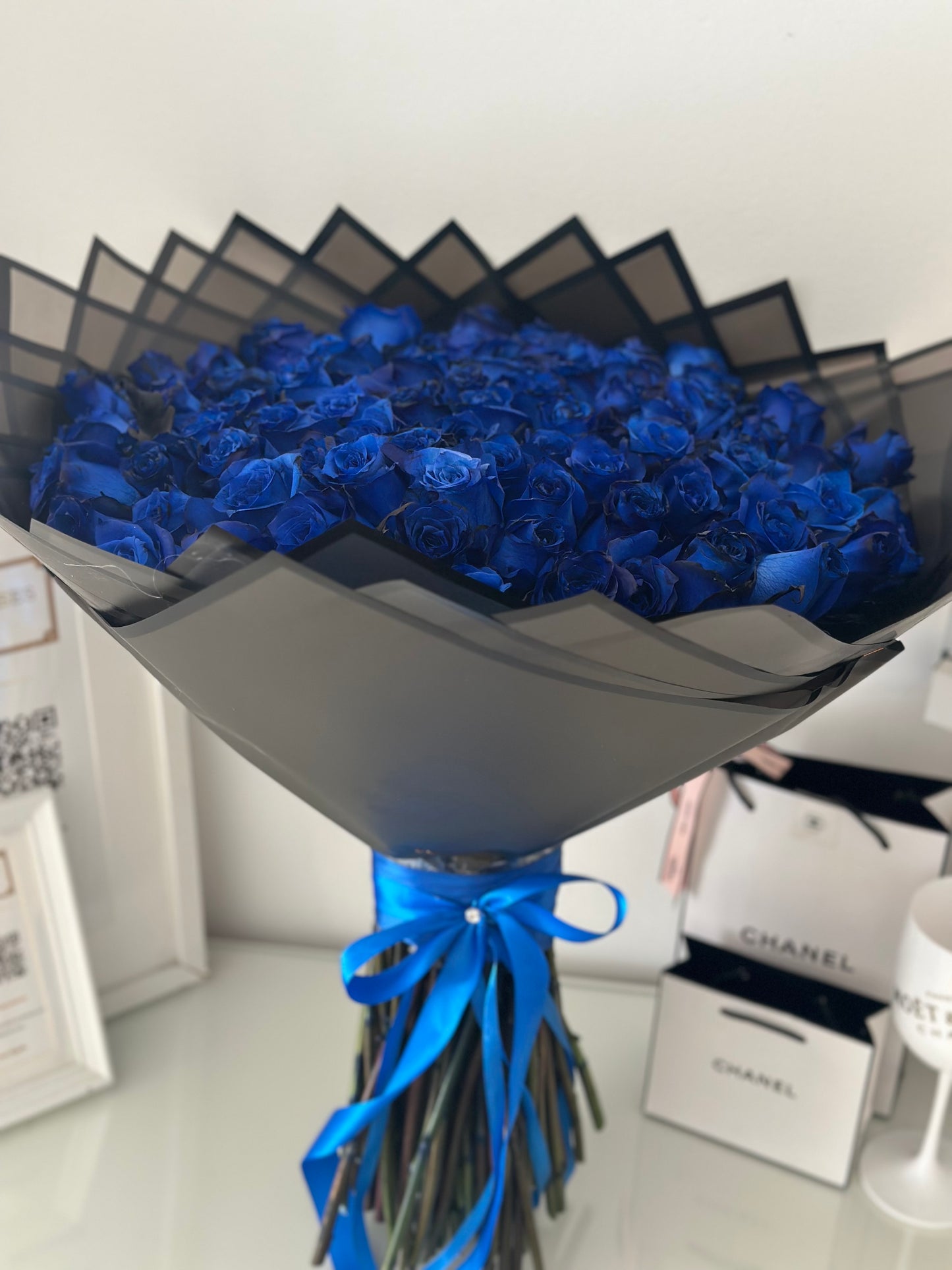 Arreglo floral de 101 rosas frescas azules con empaque negro sofisticado, exclusivo de The Prestige Roses Madrid