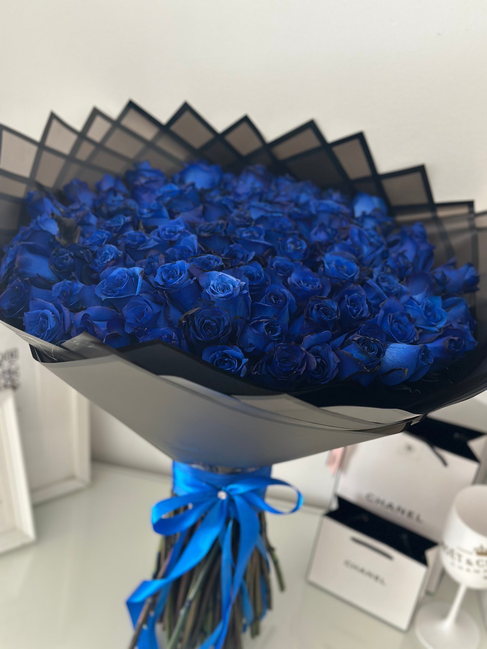 Ramo grande de rosas azules en envoltorio negro y cinta azul, floristería de lujo para entregas en Madrid Capital.