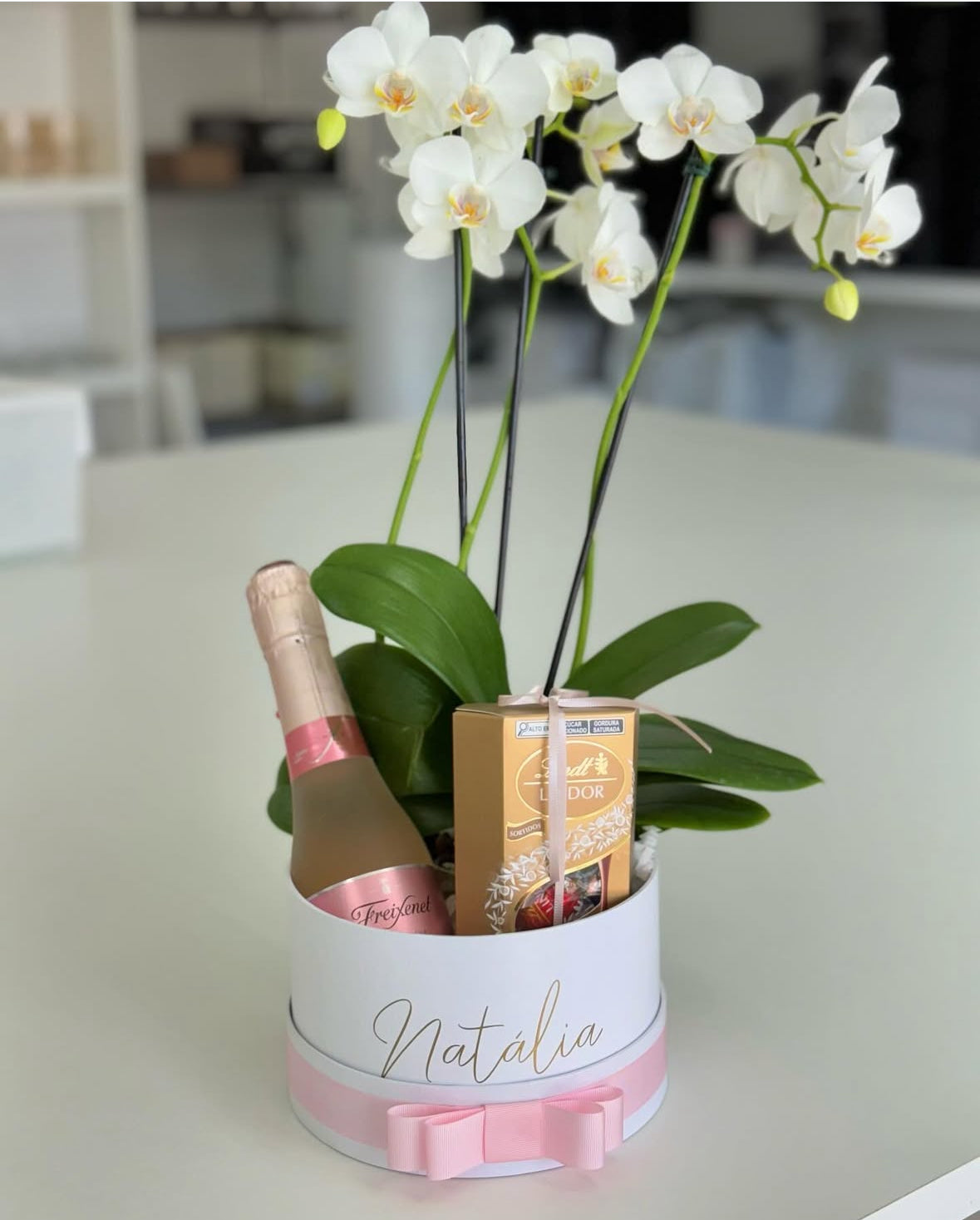 Caja elegante con orquídea viva, cava premium y Lindt Lindor y personalización.