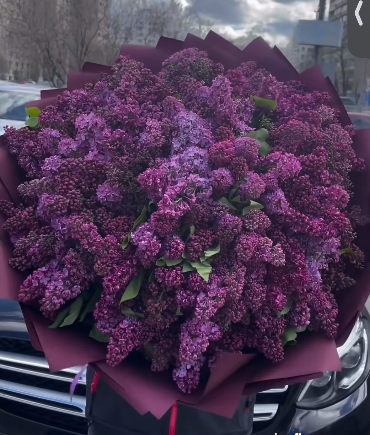 Lilas frescas en ramo voluminoso sobre mesa de terraza - arreglo floral natural y sofisticado