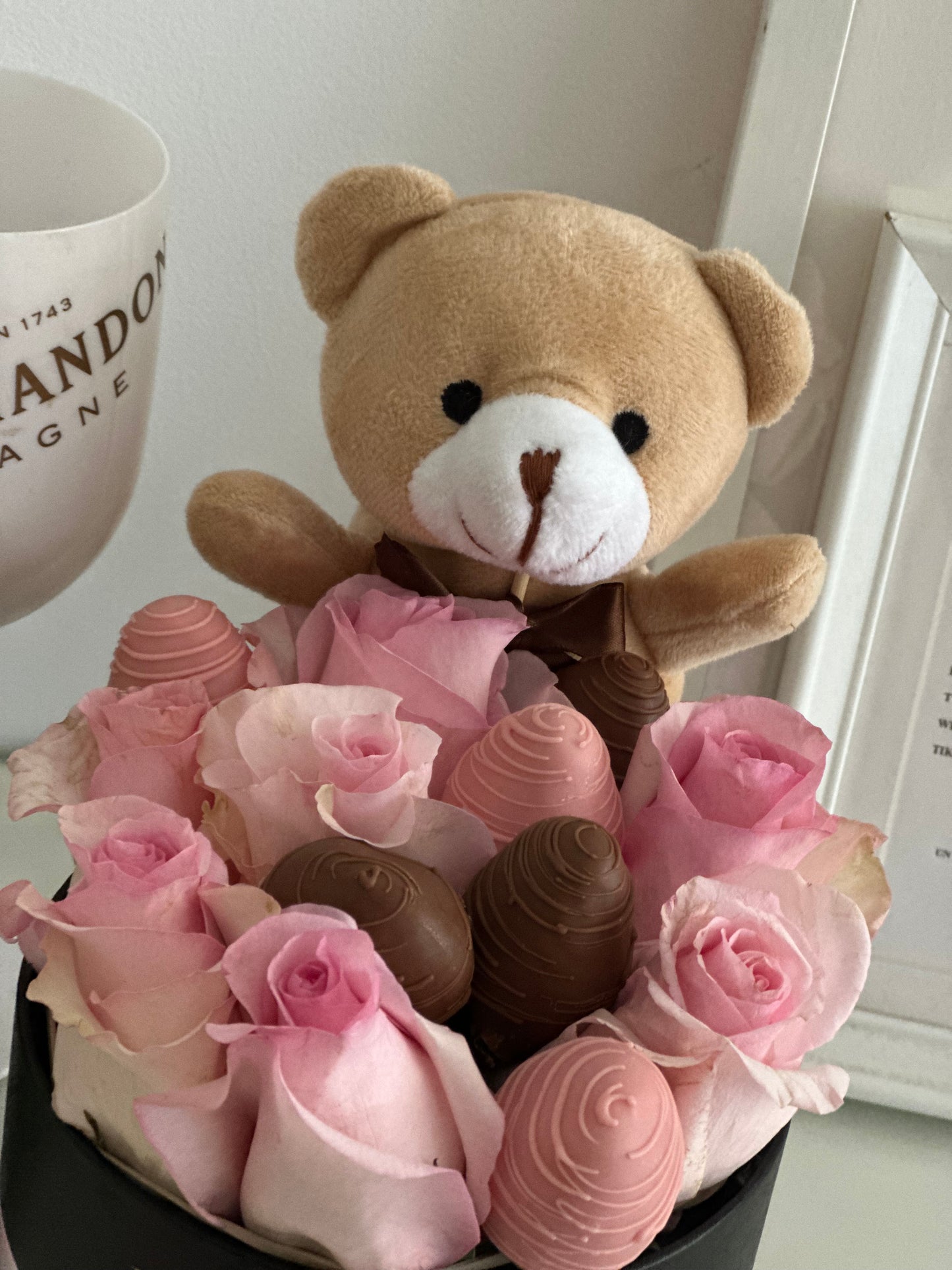 Arreglo floral premium con rosas rosadas y fresas bañadas, presentado en caja negra con lazo rosa – edición romántica y artesanal