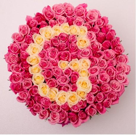 Caja premium con rosas frescas naturales, cuidadosamente dispuestas en un diseño único y sofisticado. con G