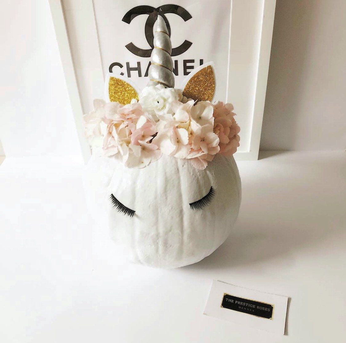 Calabaza blanca decorativa inspirada en Chanel con flores suaves, diseño elegante unicornio.