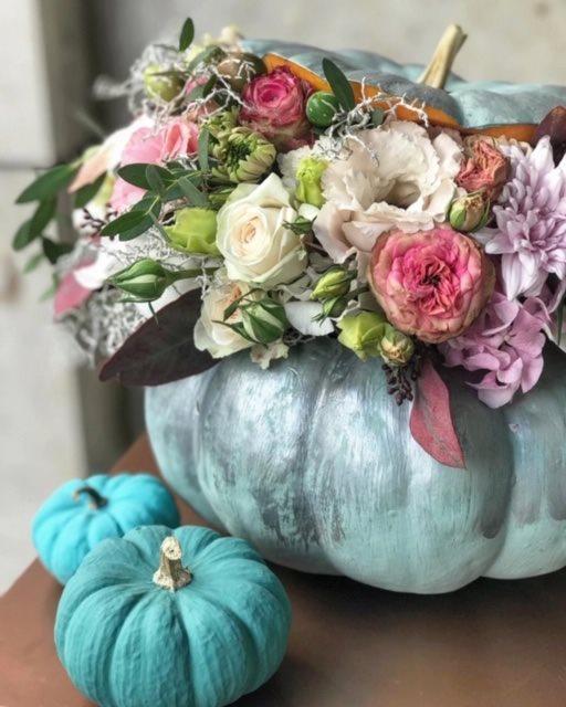 Arreglo floral de temporada con calabaza naranja y flores naturales en tonos vivos.