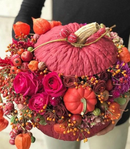 Calabaza decorativa con rosas rojas y detalles naturales, perfecta para decoración festiva