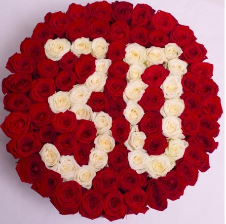 Vista superior del arreglo floral con rosas frescas en caja cilíndrica personalizada con un 30