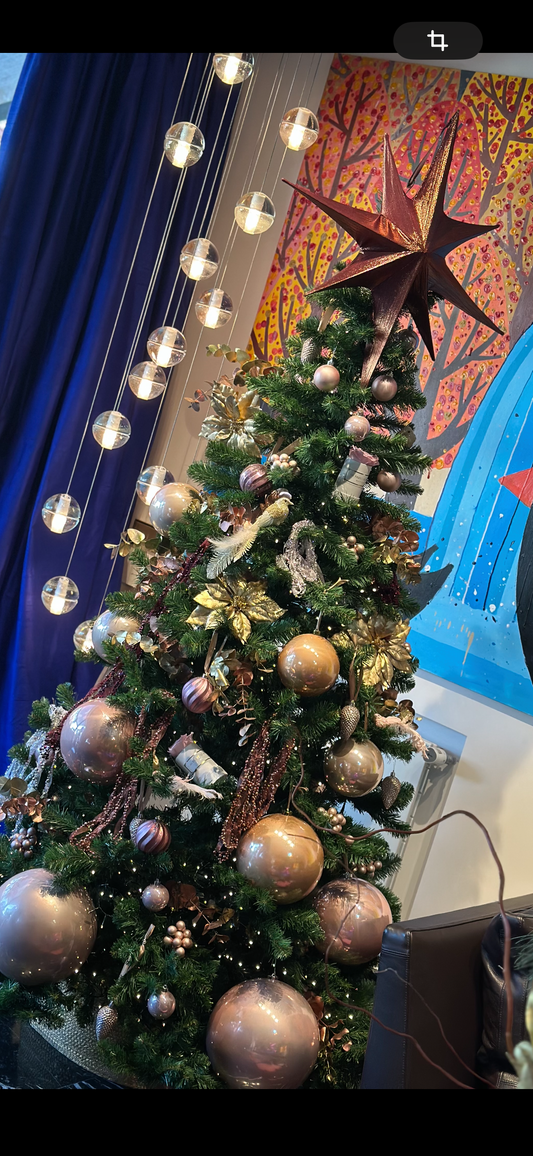 Árbol de Navidad elegante decorado con bolas doradas y tonos neutros, decoración navideña sofisticada para interiores con estilo.