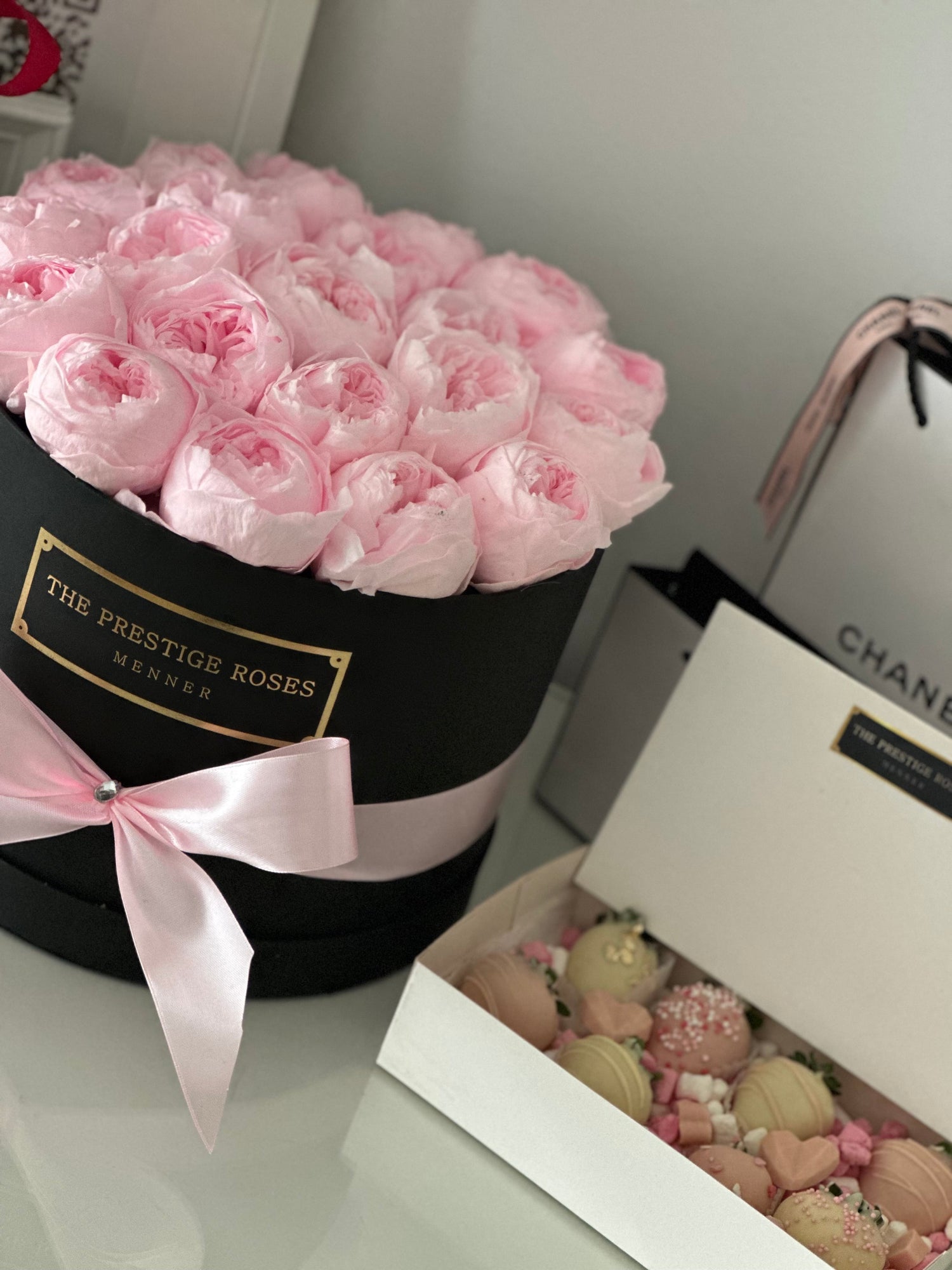 Detalle de peonías preservadas de color rosa y fresas gourmet con chocolate blanco – The Prestige Roses Madrid