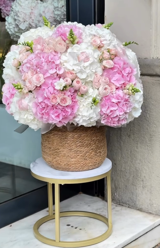 Bouquet de hortensias rosas y blancas con rosas pastel en cesta natural decorativa, regalo floral de lujo en Madrid