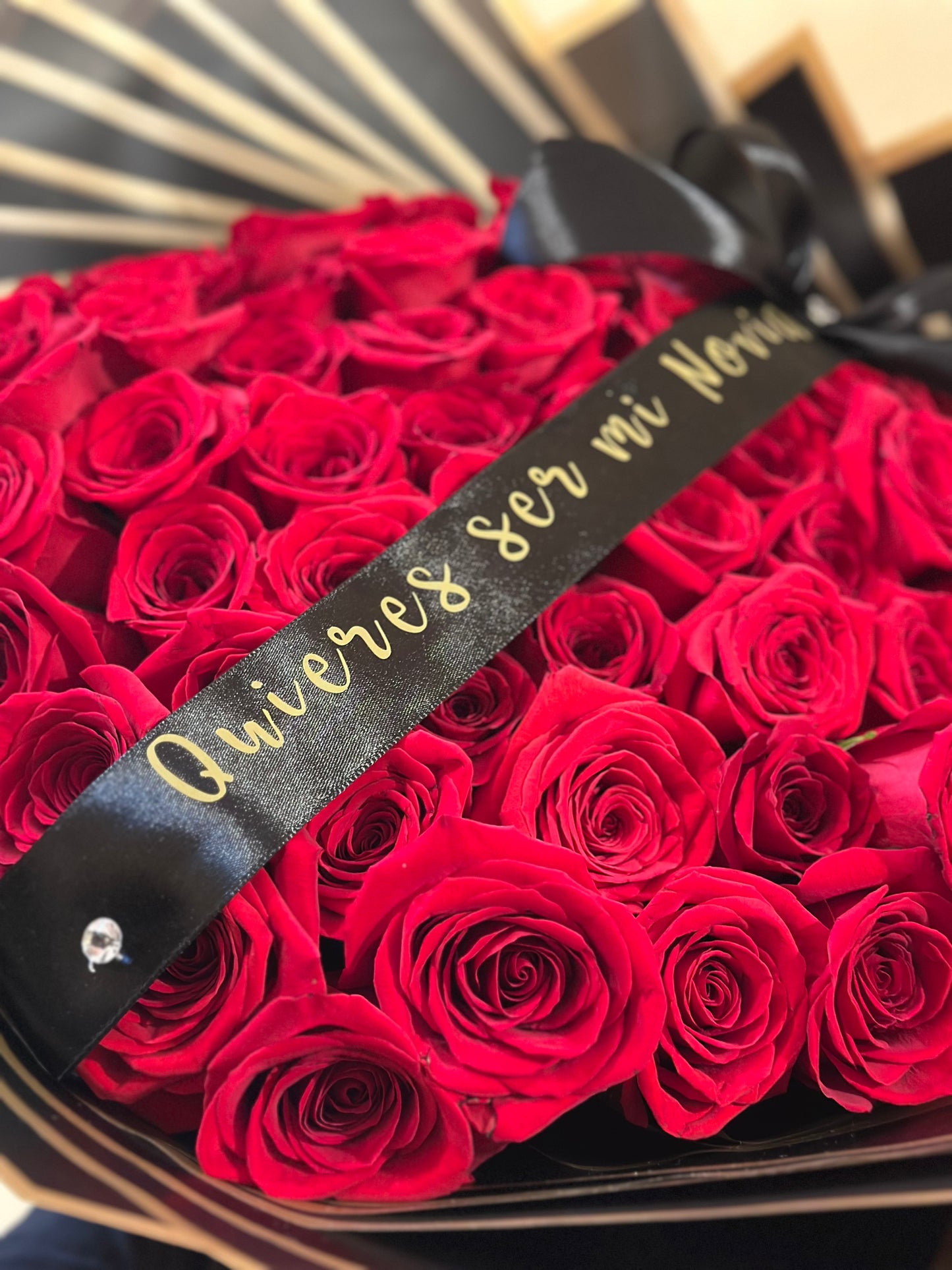 Bouquet elegante de rosas con lazo de satén negro personalizado con dedicatoria especial.