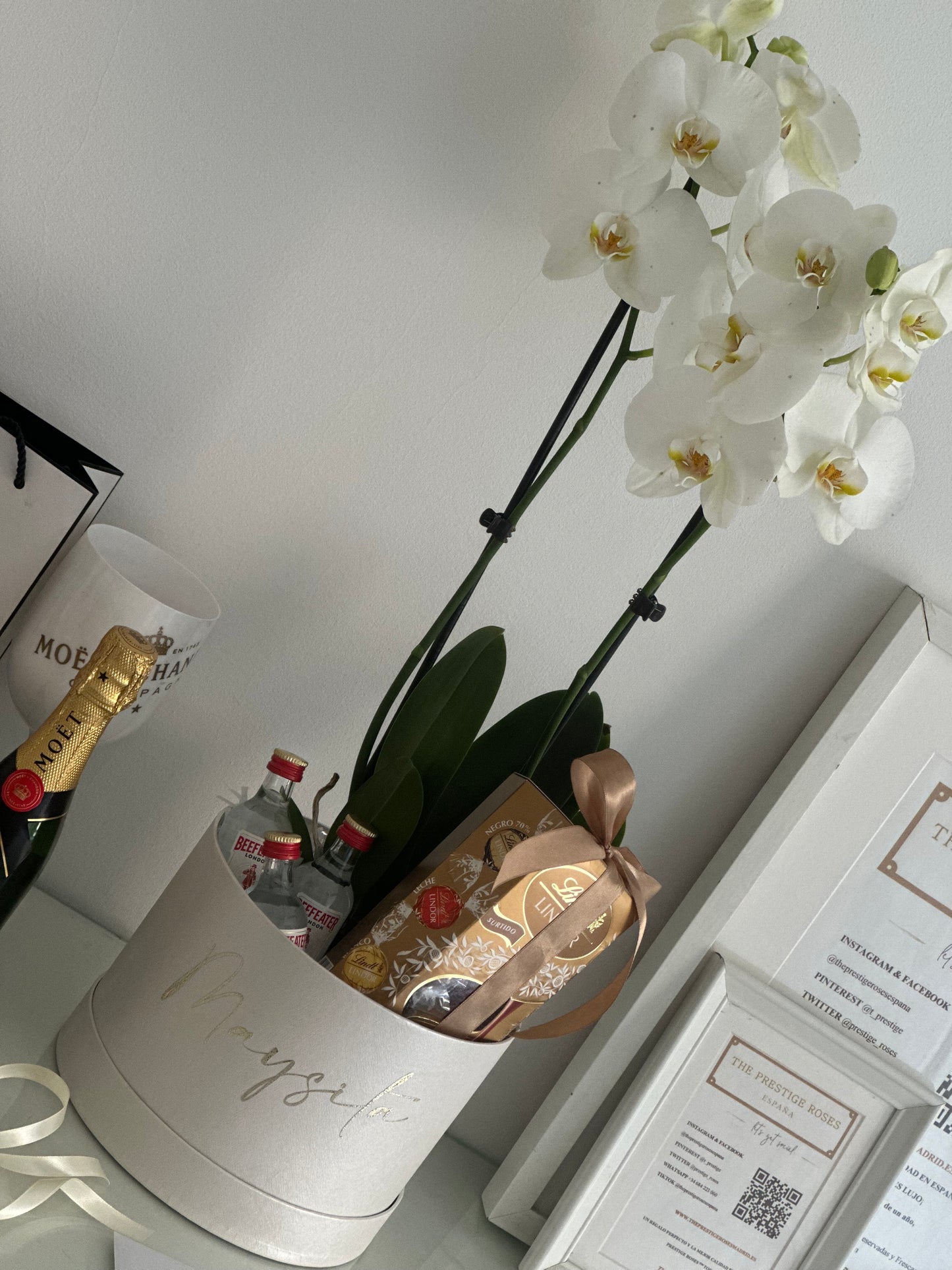 Una experiencia de regalo sofisticada y memorable. Esta exclusiva caja personalizada incluye una elegante orquídea blanca, mini botellas de ginebra premium y deliciosos bombones Lindt, creando una combinación perfecta de belleza, sabor y exclusividad para sorprender a alguien especial.