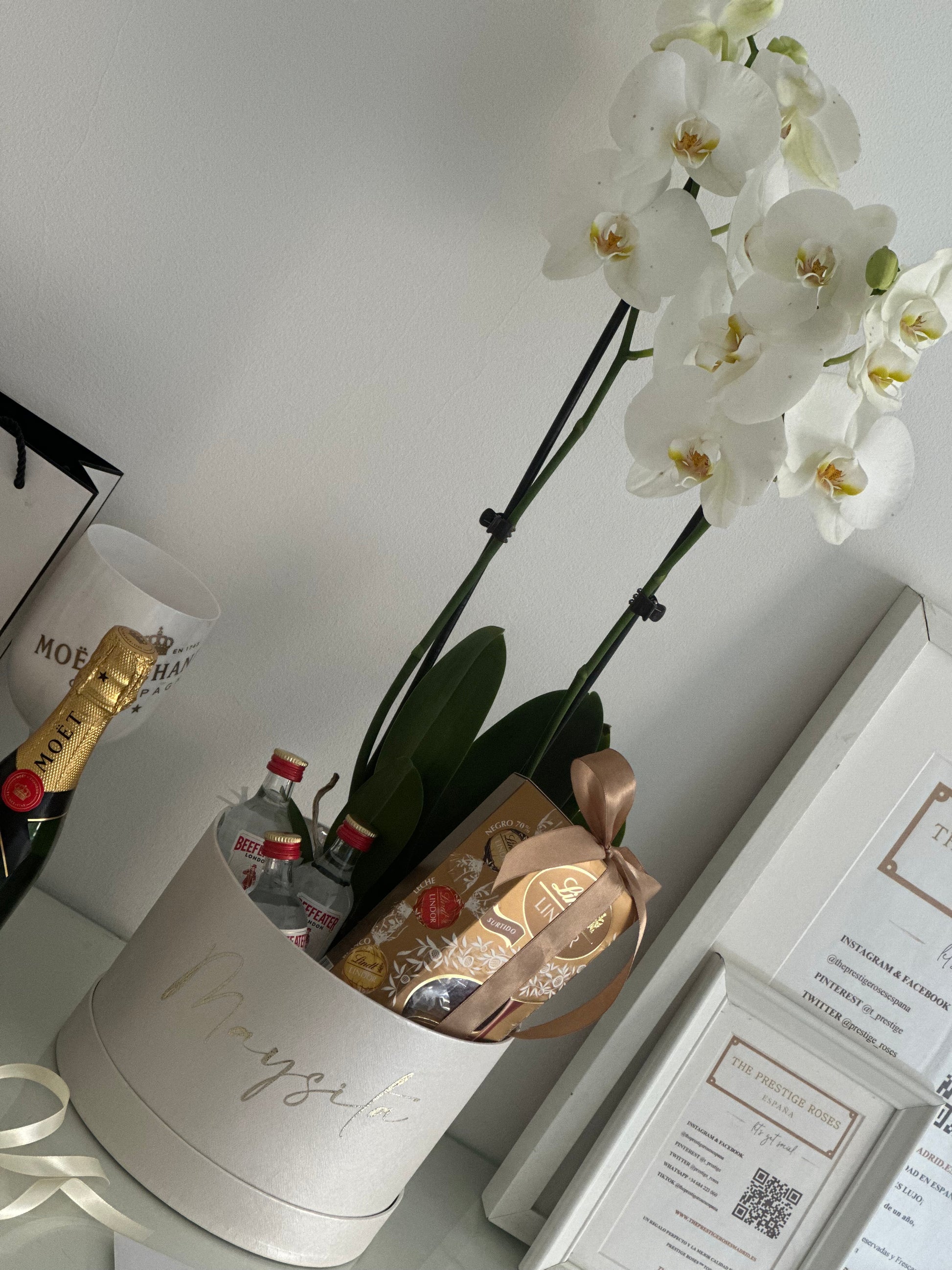 Una experiencia de regalo sofisticada y memorable. Esta exclusiva caja personalizada incluye una elegante orquídea blanca, mini botellas de ginebra premium y deliciosos bombones Lindt, creando una combinación perfecta de belleza, sabor y exclusividad para sorprender a alguien especial.
