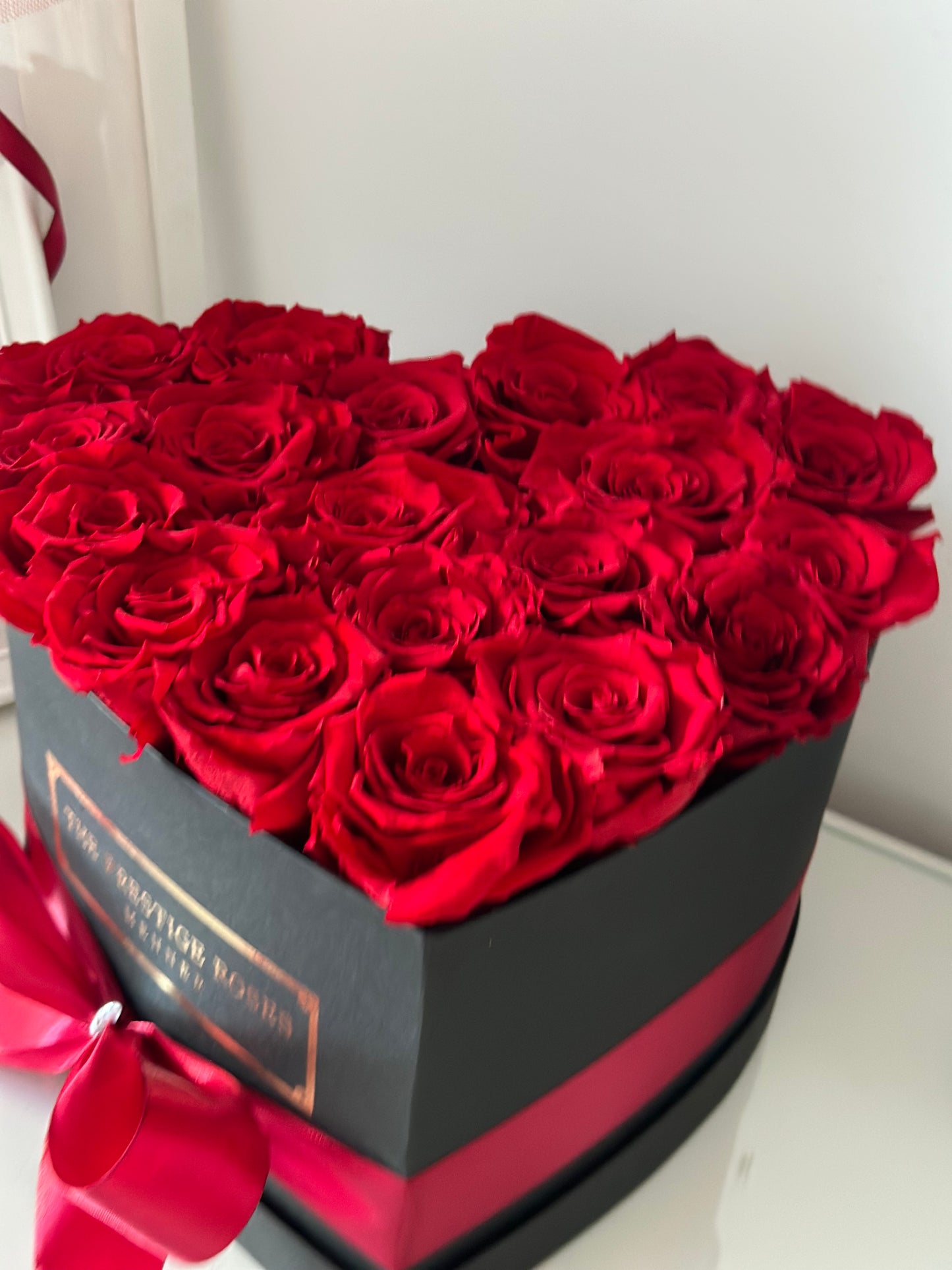 Caja elegante de rosas frescas rojas con presentación de lujo.