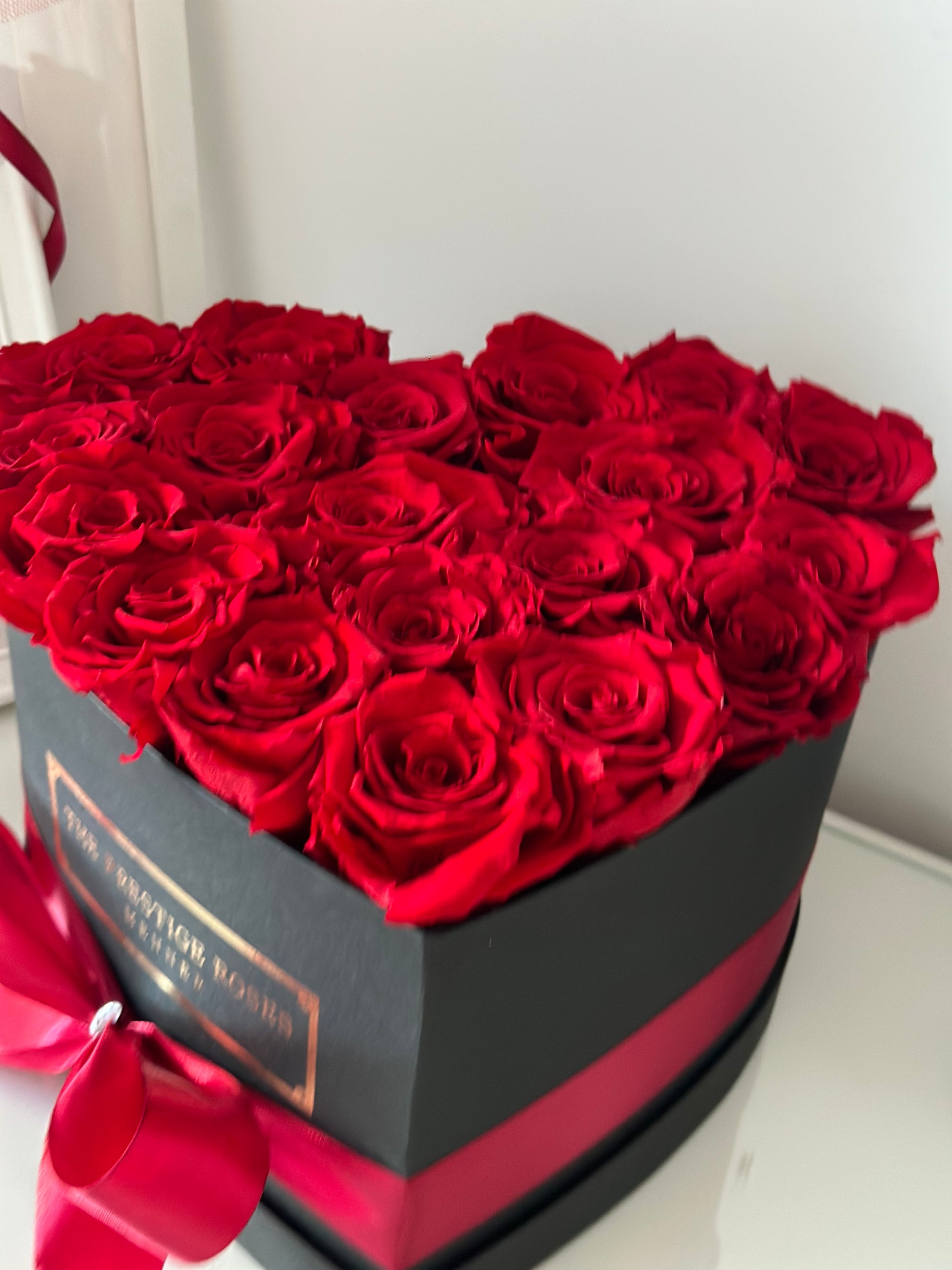 Caja elegante de rosas frescas rojas con presentación de lujo.