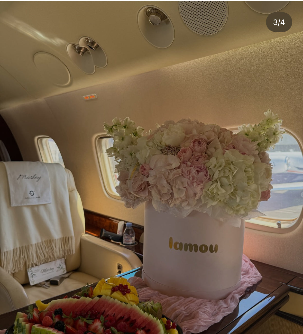 Caja floral de lujo con rosas y hortensias en jet privado, acompañada de frutas frescas – experiencia VIP personalizada