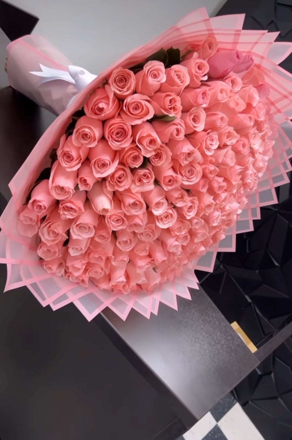 Ramo lujoso de 200 rosas rosadas envuelto en papel translúcido rosa en capas estilo abanico elegante.
EN: Luxurious bouquet of 200 pink roses wrapped in layered translucent pink fan-style paper.

