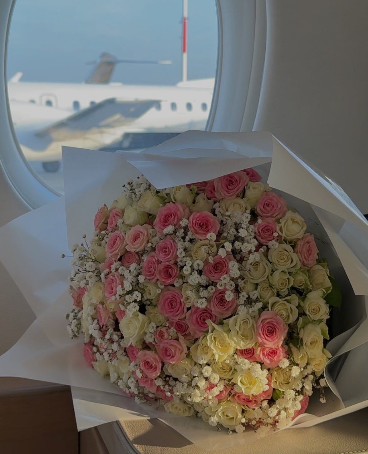 Ramo XL de rosas preservadas en jet privado, con vista de avión en pista – decoración floral de lujo