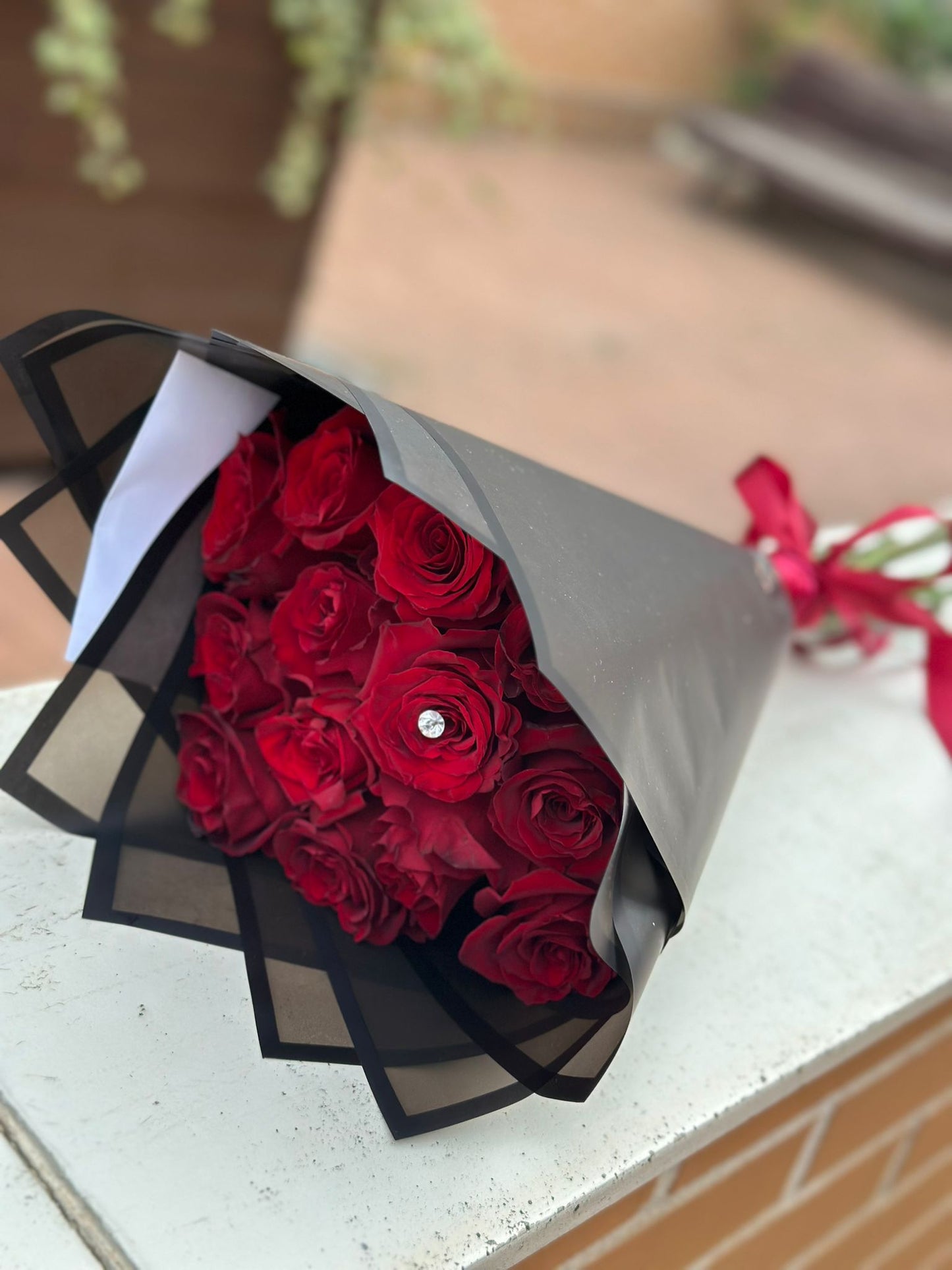  Ramo de quince rosas frescas premium presentado en estilo elegante por The Prestige Roses