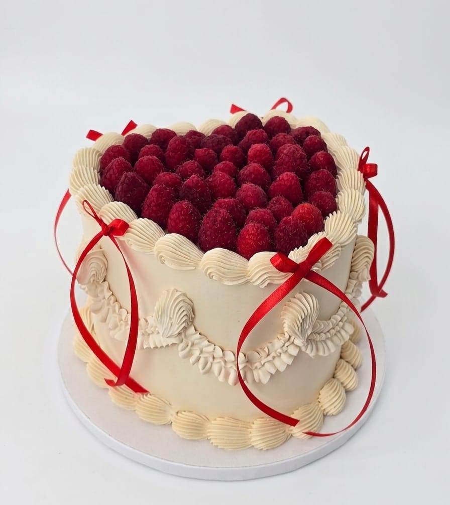 Sorprende con una exclusiva tarta artesanal decorada con abundantes frambuesas frescas y delicados detalles de pastelería. Un postre elegante y memorable para celebrar el amor, la amistad y los momentos más especiales.