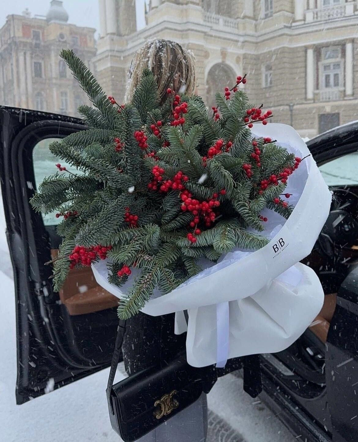 Bouquet de Navidad con ramas de pino, bayas rojas naturales y cinta decorativa, ideal para centros de mesa.
