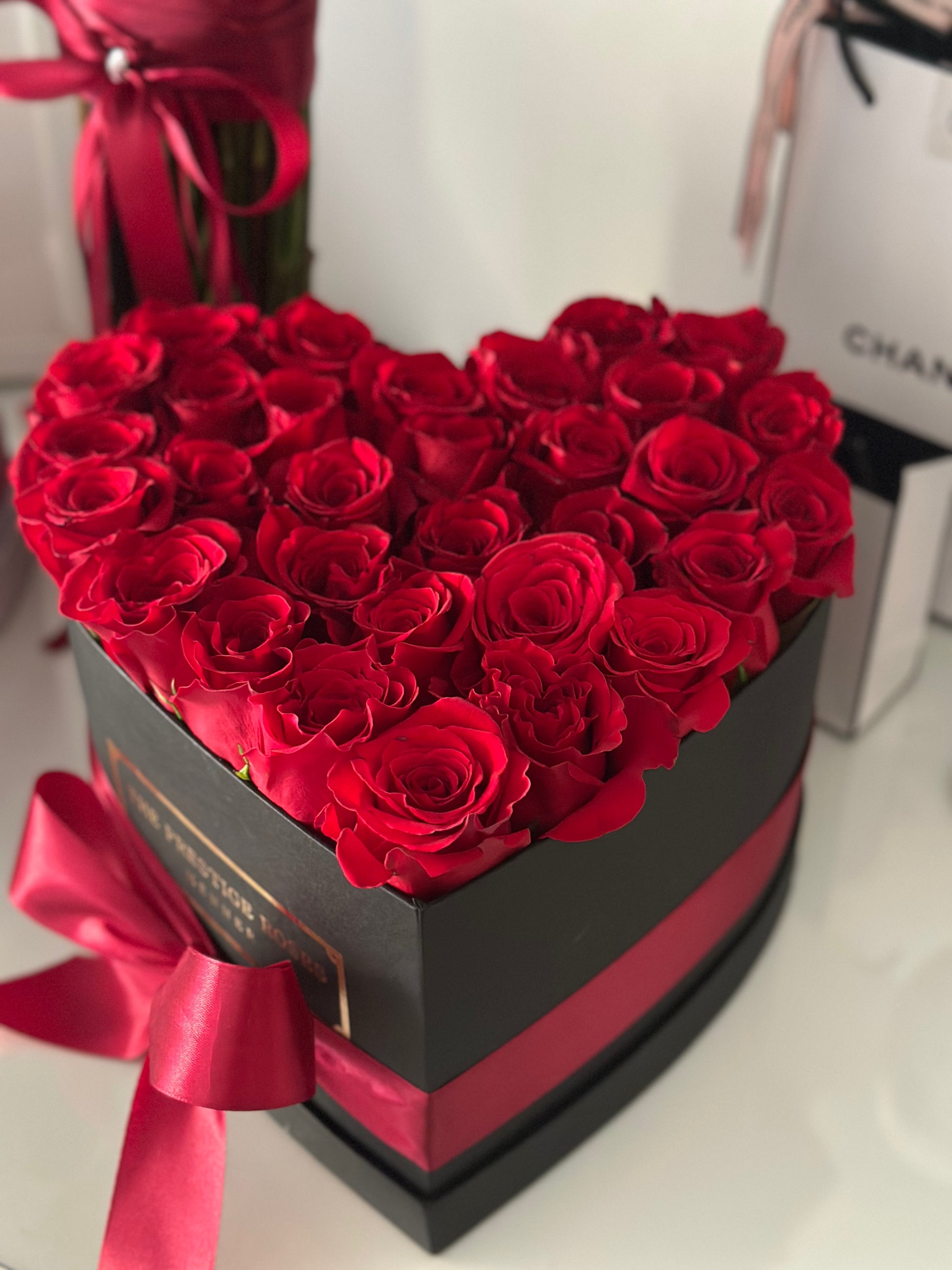 Caja elegante corazón de rosas frescas rojas con presentación de lujo.
