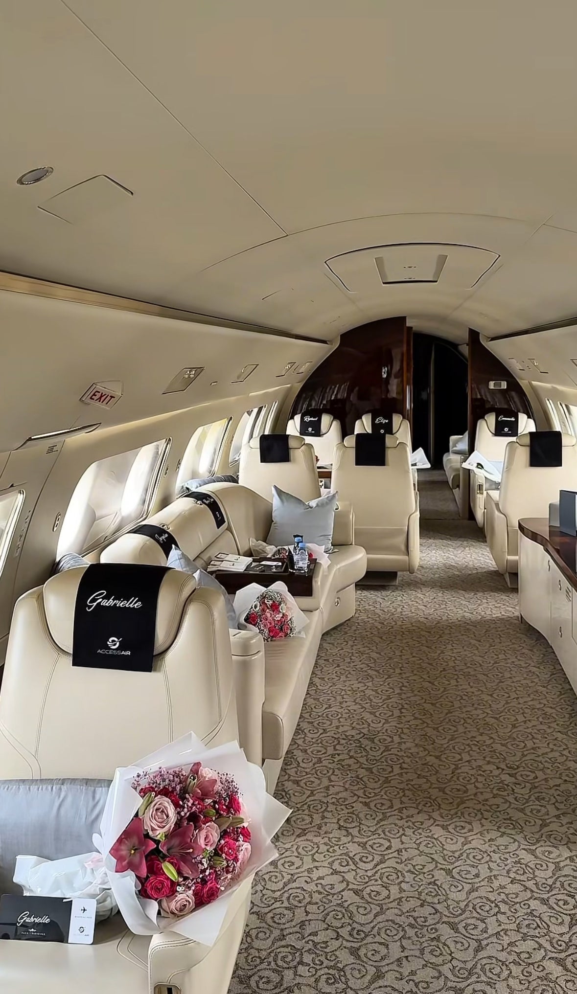 Interior de jet privado de lujo decorado con ramos de rosas y detalles personalizados en los asientos.