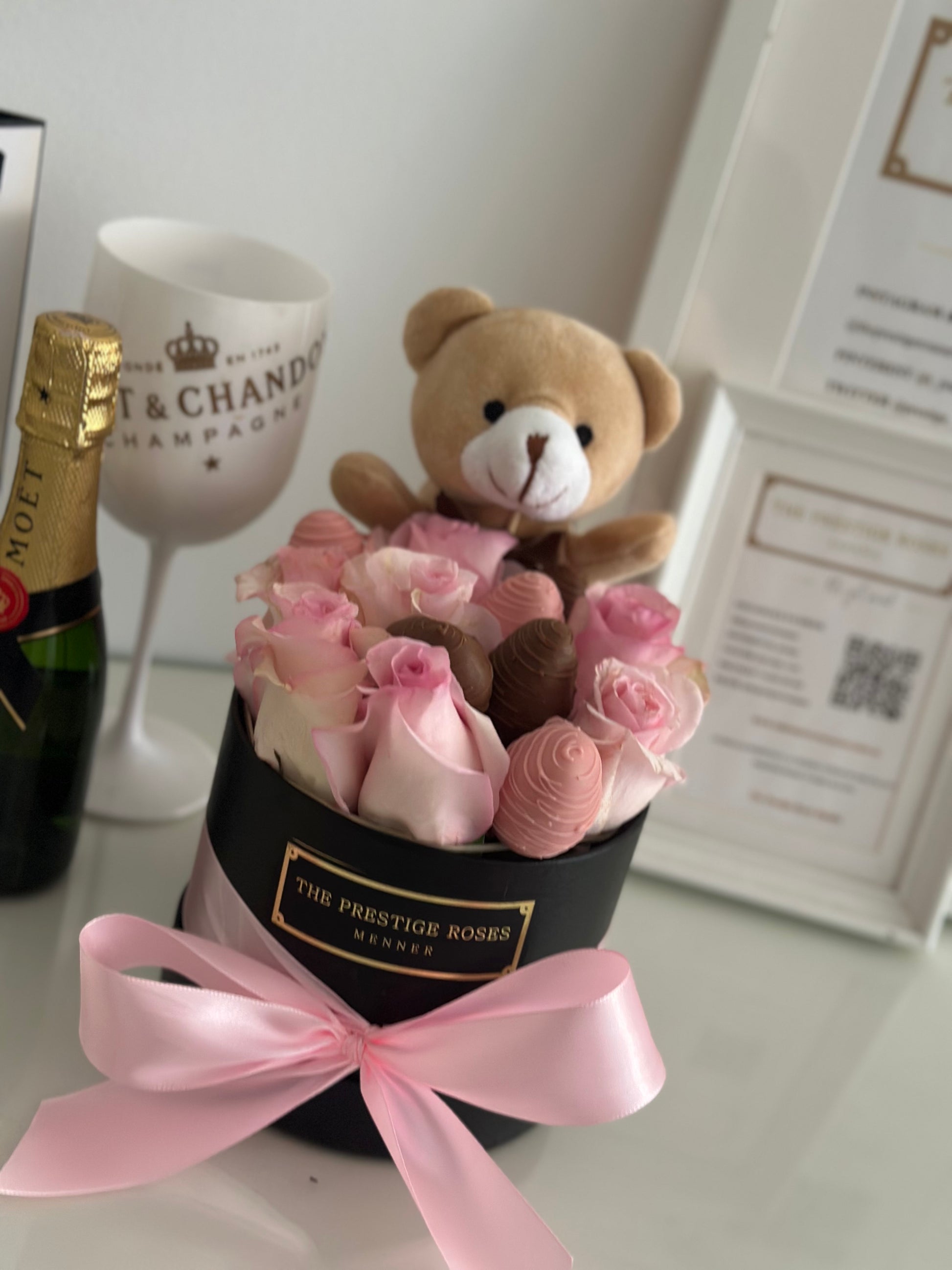 Detalle de osito de peluche entre rosas frescas rosas y fresas bañadas en chocolate – regalo tierno y elegante de The Prestige Roses