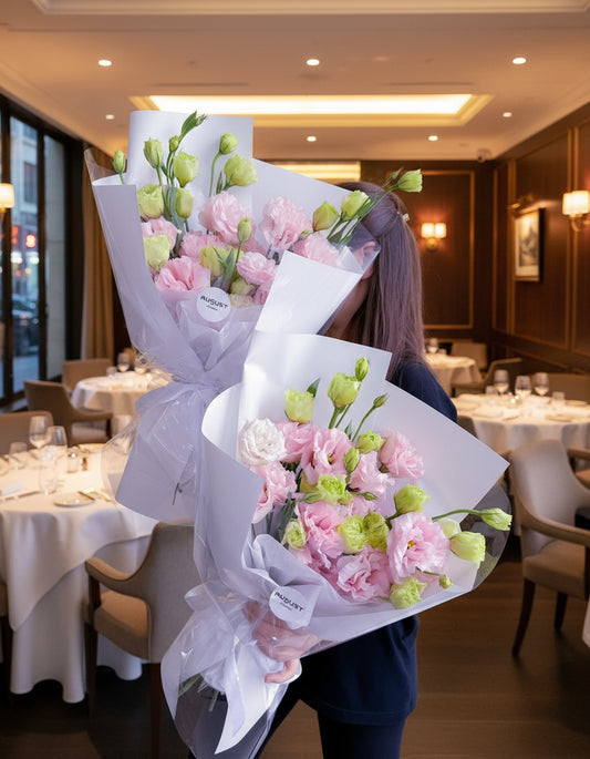 Ramos de lisianthus rosas envuelto en papel blanco elegante, sostenido por una mujer – The Prestige Roses Madrid