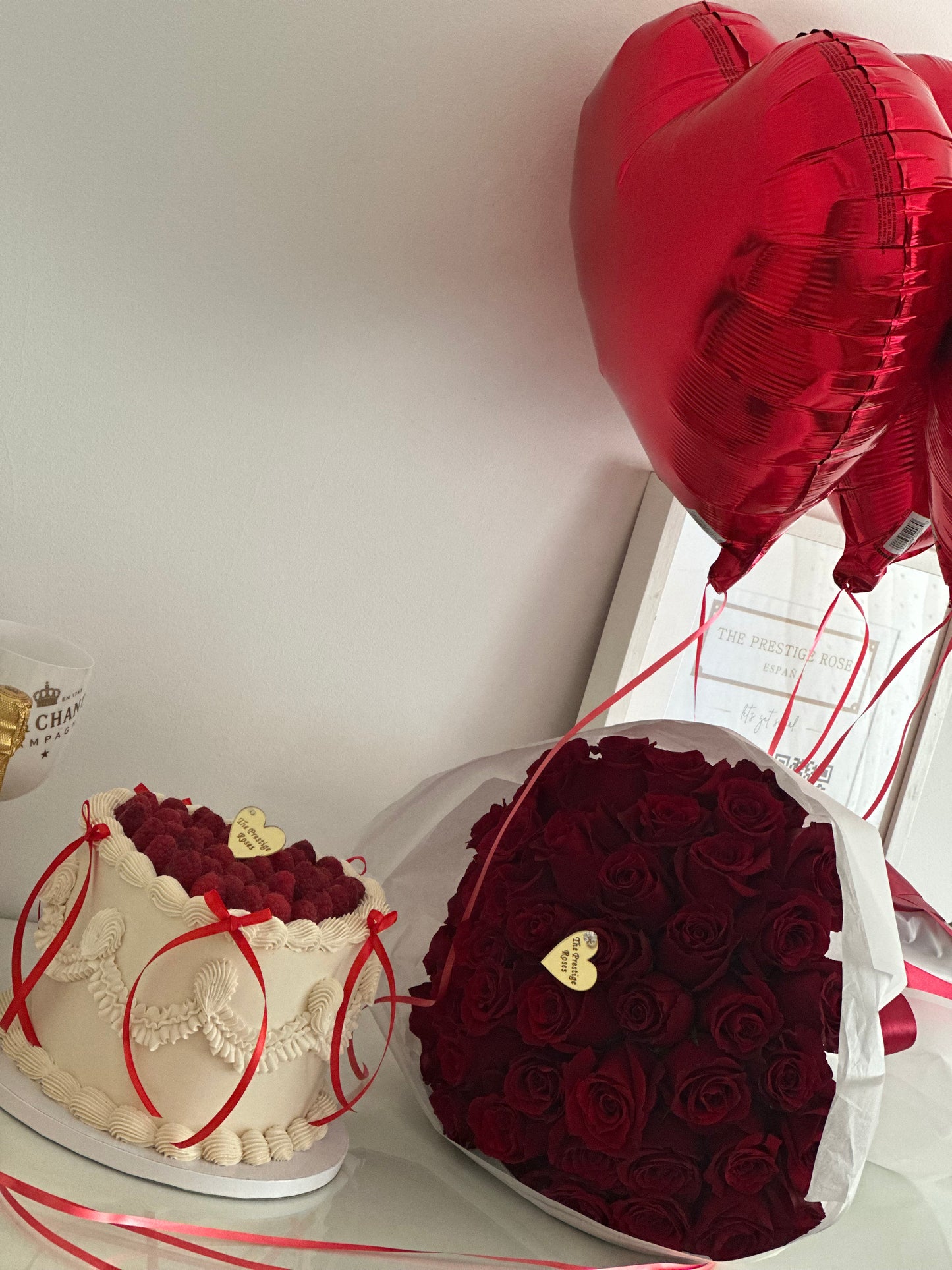 Regalo de cumpleaños con rosas rojas frescas, tarta decorada y globos corazón