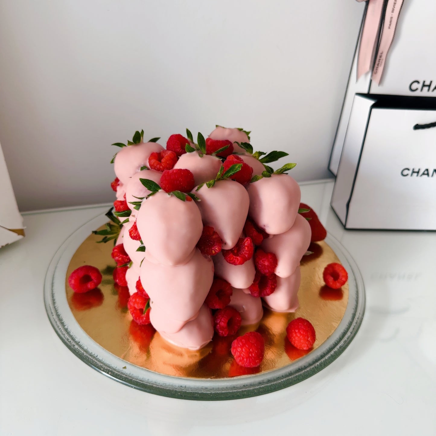 Tarta elegante con fresas, frambuesas y láminas de oro comestible